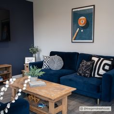 a living room filled with furniture and a painting on the wall above it's coffee table