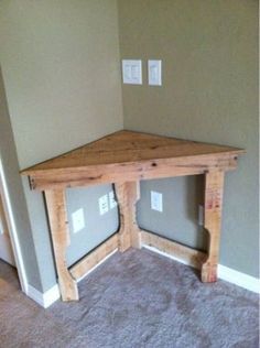 a corner table made out of pallet wood in a room with carpeted floor