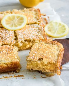 there is a lemon cake on the table with slices cut out and ready to be eaten