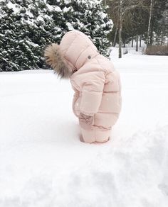 a small child is standing in the snow