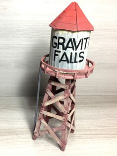 a small wooden tower with a sign that says gravity falls