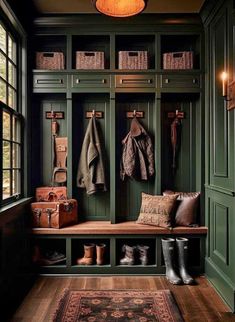 an entryway with green painted walls and wooden flooring, two coats hanging on the wall