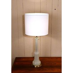 a white lamp sitting on top of a wooden table