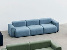 three different colored couches sitting next to each other in a room with white walls