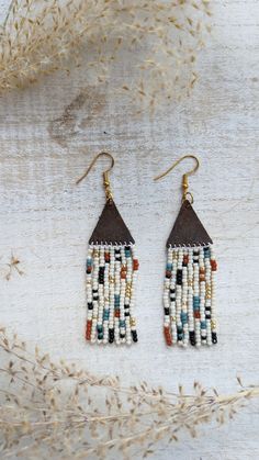 When creating these earrings I wanted to design a pattern and use a mix of colors that would enable these earrings to go with almost any outfit. These earrings are beaded by hand and the topper is made out of genuine leather. You can choose between gold, silver, and bronze hardware that is hypoallergenic.  Approx. 3 inches long Note: If you would like different colors please do not hesitate to reach out. We love custom orders and have an array of colors. Handmade White Heishi Beads Earrings, Handmade Multicolor Heishi Beads Earrings, Handmade Heishi Beads Earrings For Festivals, Brown Dangle Beaded Earrings With Tiny Beads, Brown Beaded Dangling Earrings For Festival, Brown Dangling Beaded Earrings For Festivals, Traditional Brown Beaded Earrings With Tiny Beads, Festival Brown Earrings With Colorful Beads, Handmade Heishi Beads Earrings Gift