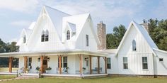 a large white house sitting on top of a lush green field