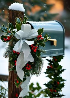 a mailbox decorated with holly and white ribbon