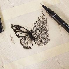 a drawing of a butterfly and flowers on a piece of paper next to a marker