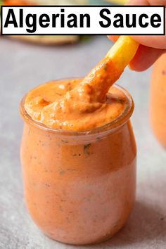 someone dipping an orange into a jar with the words, algerian sauce on it