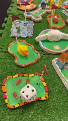 many decorated cookies are laying on the grass with flags and decorations around them, as well as a yellow rubber duck