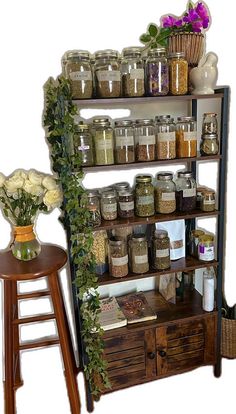 a shelf filled with jars and flowers next to a stool