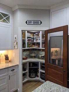 a kitchen with white cabinets and an open pantry