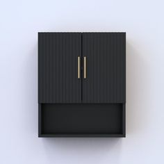 a black cabinet with two gold handles on it's sides, against a white wall