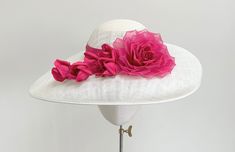 A truly elegant statement ivory and cerise pink wide brim occasion hat.  This beautiful headpiece is made in ivory sinamay straw with a flattering drop brim. The standout feature of this hat is the handmade silk dupion and organza layered rose in the most gorgeous shade of cerise, fuchsia  pink, with five matching buds that trail across the front brim. The crown is wrapped in a matching band of fuchsia silk dupion.  Measuring 44cm side to side, and 35cm front to back, and is made to a standard 2 Pink Elegant Flat Brim Fascinator, Elegant Pink Flat Brim Fascinator, Elegant Pink Flat Brim Sun Hat, Chic Pink Mini Hat For Royal Ascot, Chic Pink Sun Hat With Flat Brim, Pink Curved Brim Sun Hat For Wedding, Elegant Pink Brimmed Hats, Pink Wide Brim Wedding Sun Hat, Elegant Pink Sun Hat For Royal Ascot