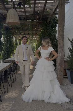 the bride and groom are walking down the path