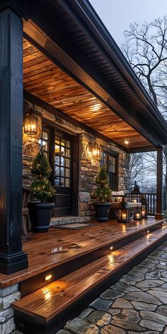 a stone house with lights on the porch