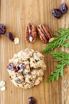 an oatmeal cookie with cranberries and nuts on a wooden table