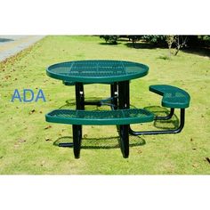 a green table and two benches in the grass