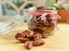 a jar filled with nuts sitting on top of a wooden table