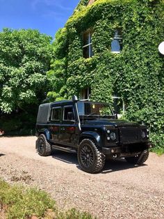 a black jeep parked in front of a large building with ivy growing on it's side