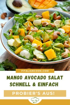 mango avocado salad with spinach and oranges in a bowl on a cutting board