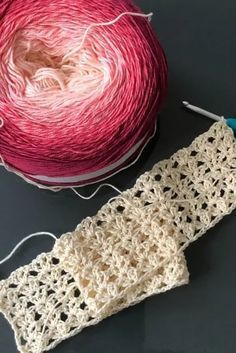 two balls of yarn sitting next to each other on top of a table with crochet