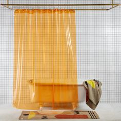 a yellow shower curtain sitting next to a bath tub