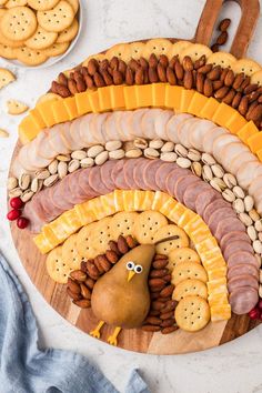 a wooden platter filled with crackers, cheeses and nuts