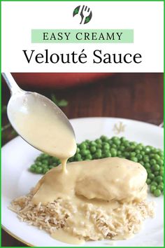 a white plate topped with mashed potatoes covered in gravy next to peas