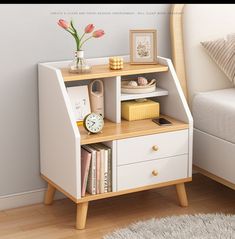 a white and wooden shelf with some books on top of it next to a bed