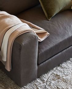 a brown couch with a blanket on top of it