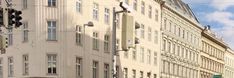 an intersection with traffic lights and tall buildings in the background on a sunny day,