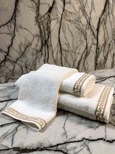 two white towels sitting on top of a marble counter