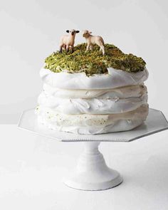 there is a cake that has sheep on top and grass on the bottom, with white frosting