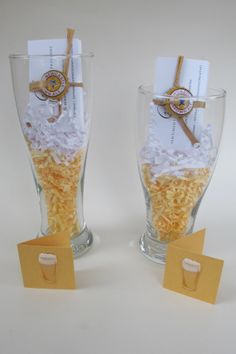 two glass vases filled with yellow and white shredded rice on top of each other