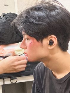 a young man is brushing his teeth with an electric toothbrush while wearing ear buds