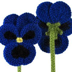 two crocheted blue flowers with green stems