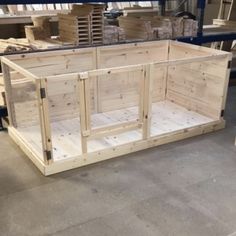 a large wooden box sitting on top of a floor next to shelves filled with boxes