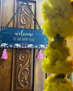 a welcome sign hanging from the side of a wooden door that says, welcome to our happy place