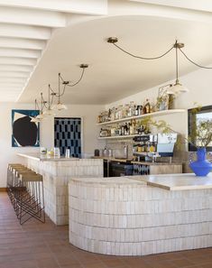 a bar with several stools and bottles on the shelves