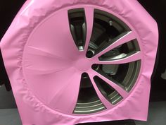 a pink car tire cover sitting on top of a black floor