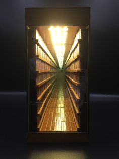 a long row of shelves filled with books in a dark room next to a wall