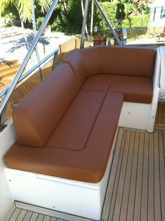 a brown and white couch sitting on top of a boat