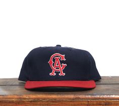 a los angeles angels hat sitting on top of a wooden table in front of a white wall