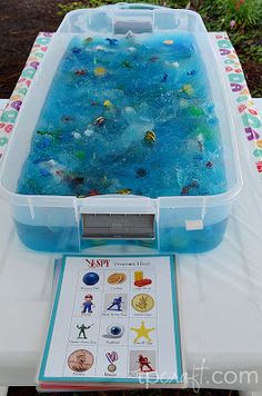 a plastic tub filled with blue liquid and lots of stickers on top of it