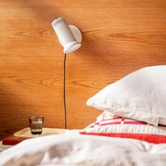 a white lamp on the side of a bed