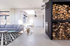 a living room filled with furniture and lots of wood stacked on top of each other