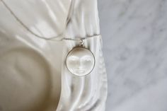 A gorgeous full moon open eye face necklace, so dainty and refined. Every moon cabochon (20mm) is hand-carved, so every little man in the moon will look slightly different. Set in a sterling silver setting and suspended from delicate sterling silver chain. Each cabochon is carved in Bali by the best Balinese master craftsmen and has extremely fine detail. Wonderful bohemian, effortlessly chic.  Wear it on its own or layer it with other necklaces. Model wears a 22" length. Made using the highest White Round Necklace With Sun And Moon Design, White Sun And Moon Design Round Necklace, Carved White Sterling Silver Necklaces, White Pendant Necklace With Sun And Moon Design, White Sun And Moon Round Pendant Jewelry, White Sun And Moon Design Round Pendant Jewelry, White Pendant Jewelry With Sun And Moon Design, White Sun And Moon Pendant Jewelry, White Sun And Moon Design Pendant Jewelry