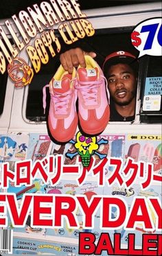 a man holding up pink shoes in front of a bus with stickers on it