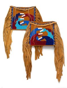 two native american style saddles with fringes and designs on the sides, one in brown